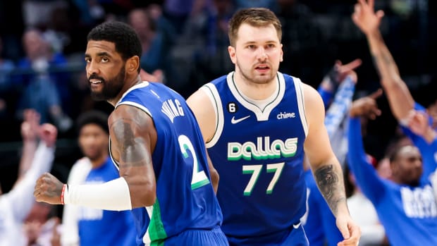 Mavericks guard Kyrie Irving celebrates a basket with teammate Luka Doncic